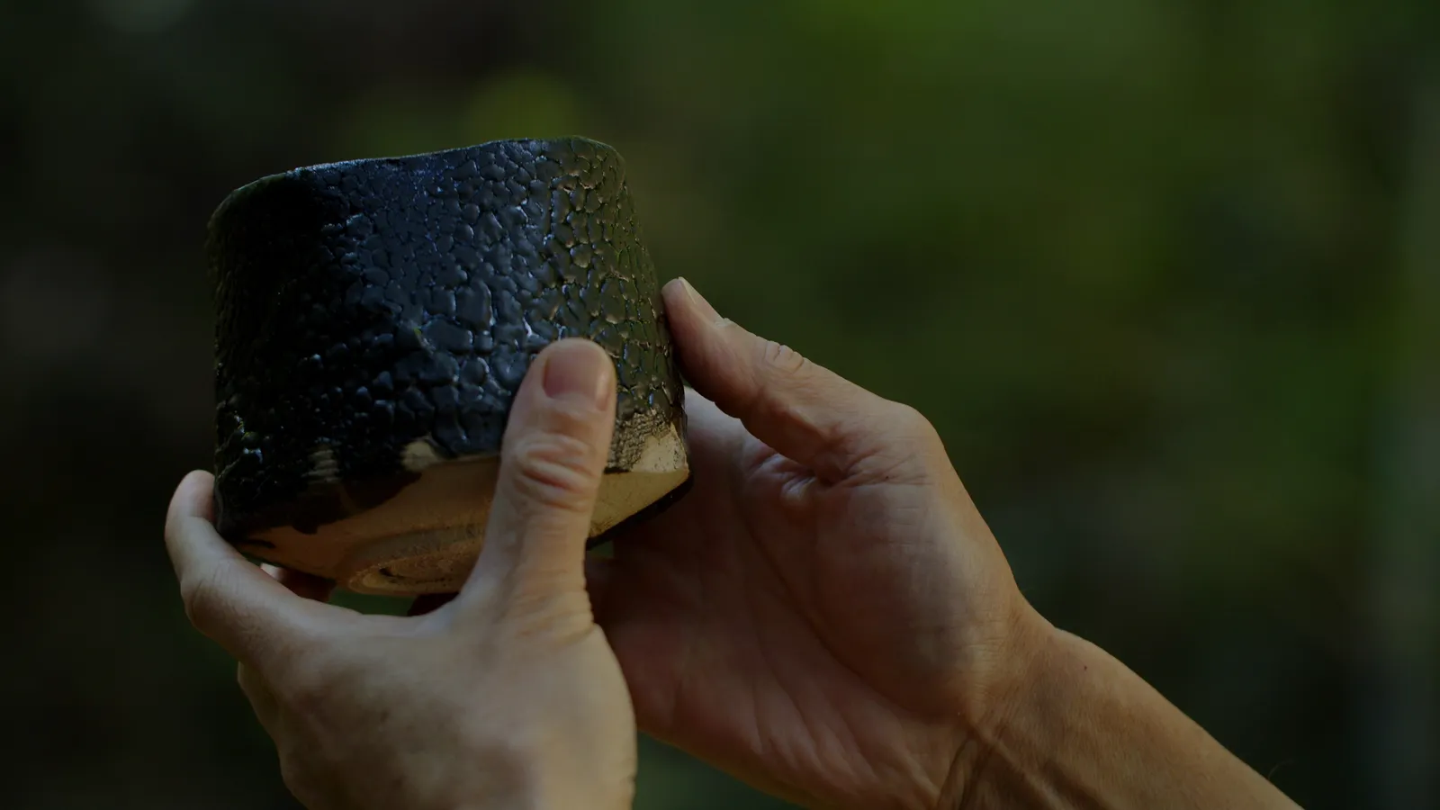 瀬戸黒の茶盌を両手で持つ手元