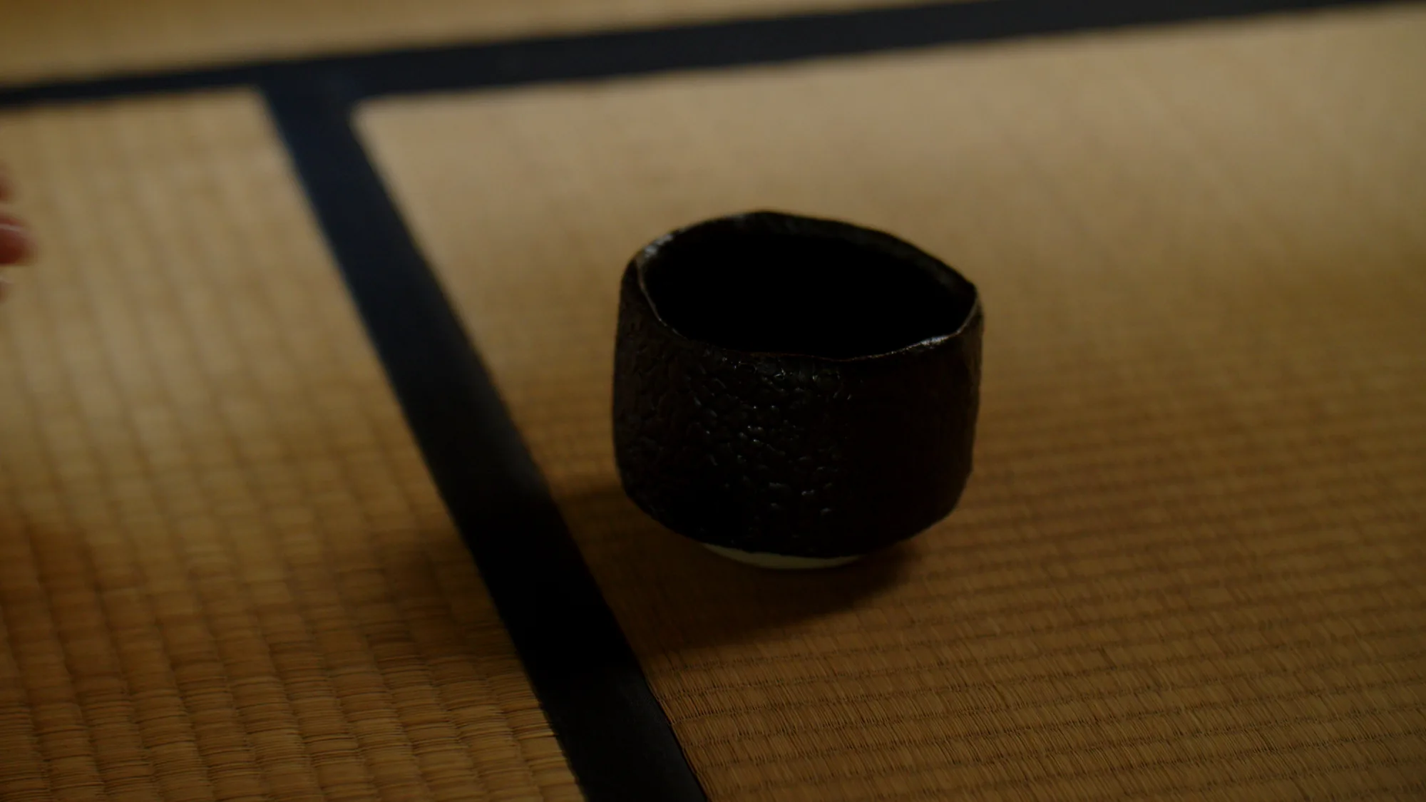 畳の縁の内に置いた、瀬戸黒の茶盌